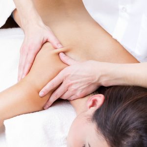 Woman enjoying shoulder massage at beauty spa